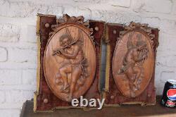 Paire d'antiques panneaux muraux en bois sculpté représentant des putti anges musiciens avec du velours